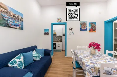 a living room with a blue couch and a table at Antony Mondello Guest House, appartamento a 1 minuto a piedi dalla spiaggia di Mondello in Palermo