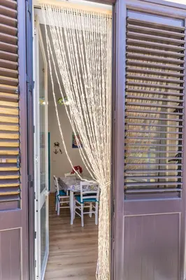 a room with a window with curtains and a table at Antony Mondello Guest House, appartamento a 1 minuto a piedi dalla spiaggia di Mondello in Palermo