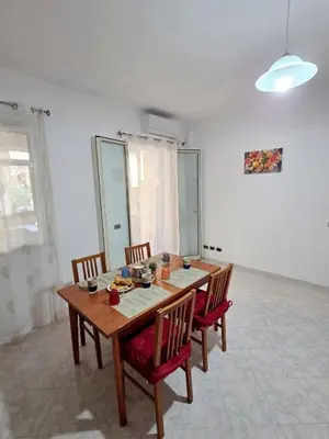 a dining room with a wooden table and chairs at Casa Pino in Isola delle Femmine