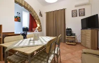 a dining room with a table and a tv at Nice Home In Capaci With Wifi in Capaci