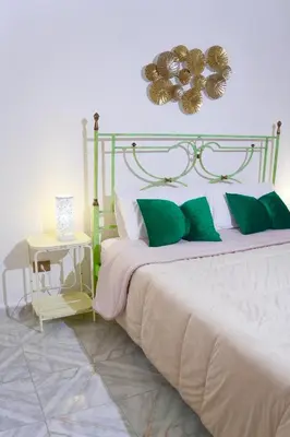 a bedroom with a large bed with green pillows at Chic Angolo di Anita in Palermo