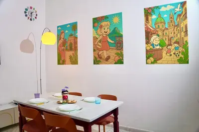 a dining room table with four paintings on the wall at Chic Angolo di Anita in Palermo