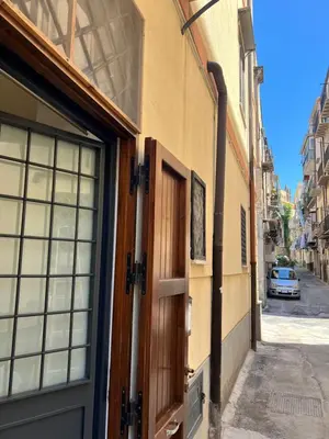 a door to a building with a car parked on a street at Kiccifù home in Palermo
