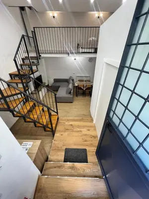 a staircase leading up to a room with a couch and a table at Kiccifù home in Palermo