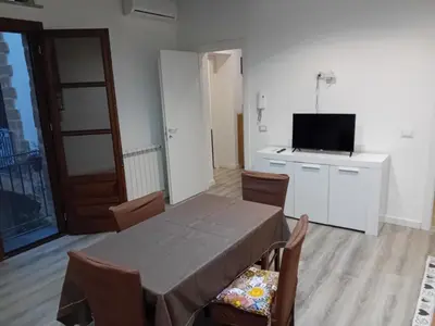 a dining room with a table and a flat screen tv at Vernagallo's house in Palermo