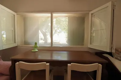 a dining room table with two chairs and a window at Villa Barbera - Terrace overlooking the sea in Bagheria