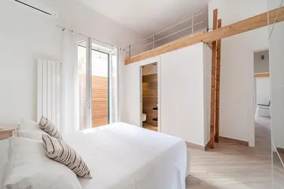 a white bedroom with a large white bed with pillows at Casa Clio - Mondello Home in Palermo