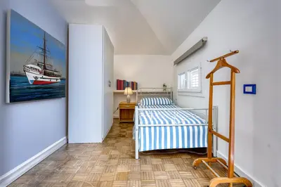 a bedroom with a bed and a painting of a sailboat at VFH Villa Cala del Cuore con piscina, 50 m dal mare in Santa Flavia