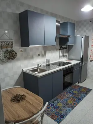 a kitchen with blue cabinets and a table and a sink at Lucy home in Palermo