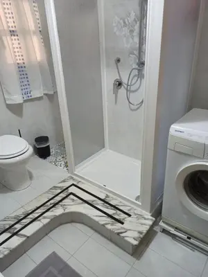 a white bathroom with a shower and a toilet at Lucy home in Palermo