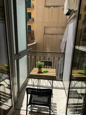 a balcony with a table and chairs on a balcony at nuova oreto stazione rooms in Palermo