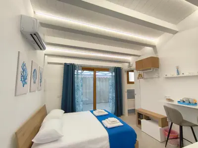 a small room with a bed and a table and a desk at Damasa House in Balestrate
