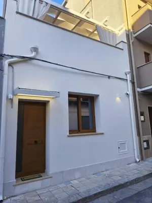 a white building with a door and a window at Damasa House in Balestrate