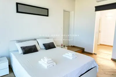 a bedroom with a white bed with towels on it at Appartamento in villa vista mare con jacuzzi By Sicily Home Solutions in Balestrate