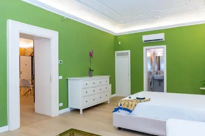 a green room with a bed and a white dresser at 4Quarti in Palermo