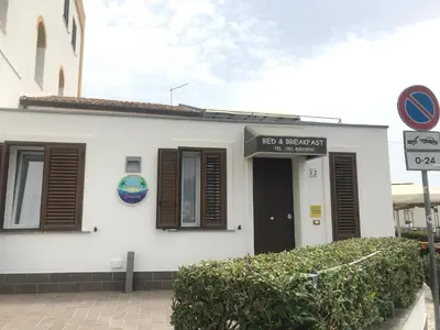 a white building with brown shutters on it at b&b Simpaty in Mondello