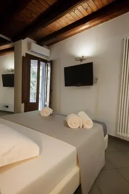 two beds in a room with a tv on the wall at Qanat House con Terrazzo Privato in Palermo