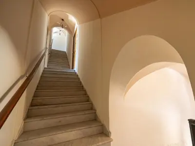 a staircase in a building with white walls and arches at Dimora Puccini by Holiday World in Castellammare del Golfo