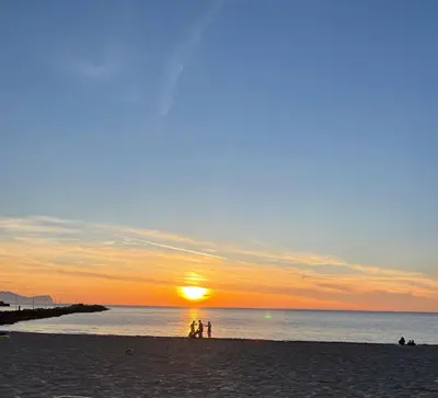 two people standing on a beach at sunset at La Casa dei Limoni - Your Sicilian Getaway near the sea in Terrasini in Terrasini
