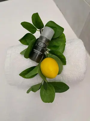 a bottle of essential oil and a lemon on a towel at La Casa dei Limoni - Your Sicilian Getaway near the sea in Terrasini in Terrasini