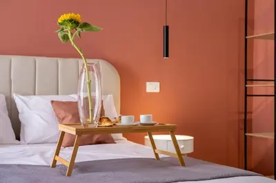 a vase with a flower on a table next to a bed at Corallo - Cantunera Old Town Apartments in Palermo