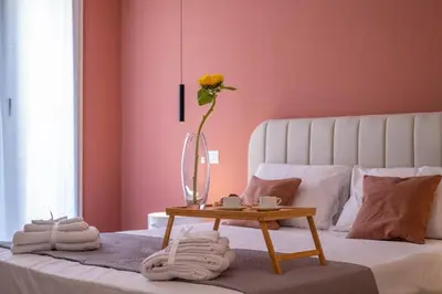 a vase with a flower on a bed with a table at Corallo - Cantunera Old Town Apartments in Palermo