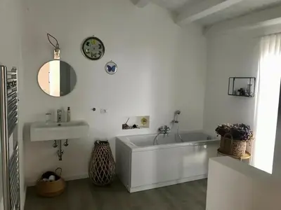 a white bathroom with a tub and a sink at Casa Mulinazzo in Cinisi