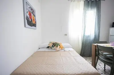 a bed in a room with a table and a window at inHouse Palermo in Palermo