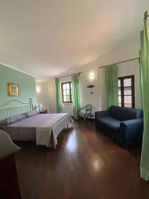 a bedroom with a large bed and a couch at Casa Mini' in Palermo