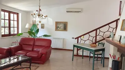 a living room with a red couch and a table at Casa Mini' in Palermo