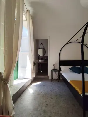 a bedroom with a bed and a large window at Cà Mami Rooms in Palermo