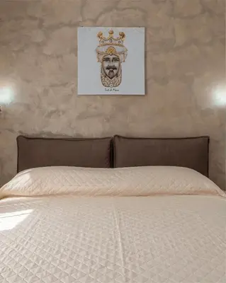 a bed with a headboard and a picture on the wall at Airoldi Home in Palermo