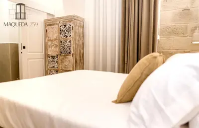a bedroom with a white bed and a wooden cabinet at Maqueda 259 - In Palermo's Lively Heart in Palermo
