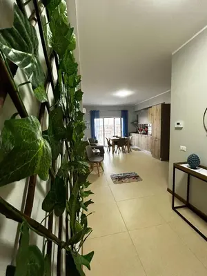a living room with a large green plant at Sole Blue Apartment in Balestrate