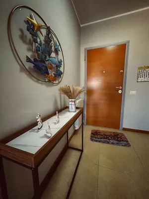 a room with a table and a wooden door at Sole Blue Apartment in Balestrate
