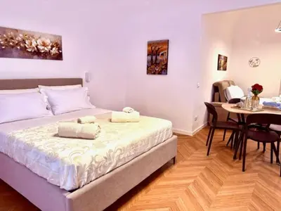 a bedroom with a bed and a dining room with a table at Casetta Lulù Palermo centro in Palermo