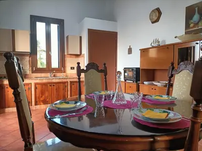 a kitchen with a table with plates and glasses on it at CAGNINA Apartments in Balestrate