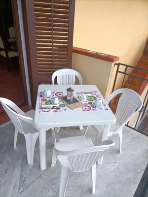 a white table and chairs with a tea set on it at CAGNINA Apartments in Balestrate