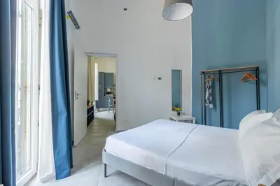 a bedroom with a white bed and blue walls at Panurban Apartments by Wonderful Italy in Palermo