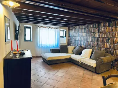 a living room with a couch and some books at Cala Costa in Palermo