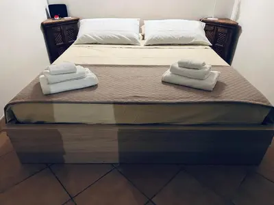 a bed with two towels on top of it at Cala Costa in Palermo