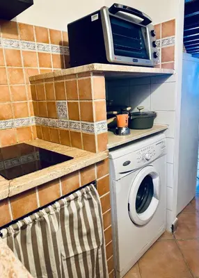 a kitchen with a washing machine and a microwave at Cala Costa in Palermo