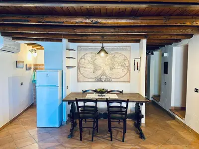 a dining room with a table and a map on the wall at Cala Costa in Palermo