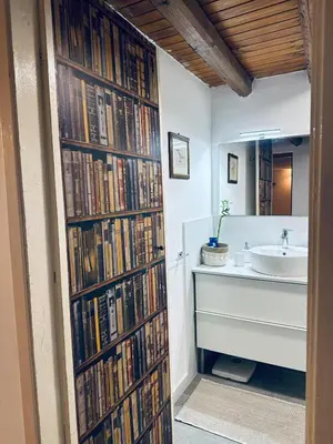 a bathroom with a large wall of books at Cala Costa in Palermo