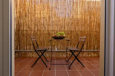 a table with two chairs and a bowl of fruit at Suite le palme in Aspra