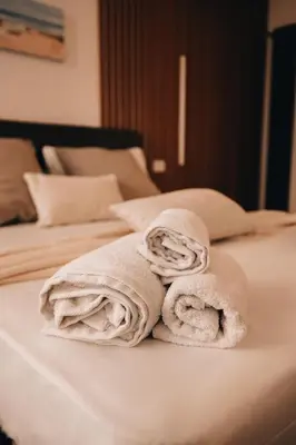 a pile of towels sitting on top of a bed at Suite le palme in Aspra