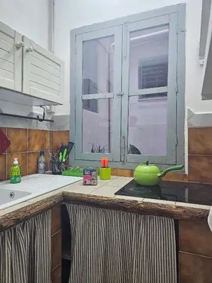 a kitchen counter with a green pot on a stove at A al Quadrato in Palermo