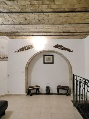 an archway with a table and a bench in a room at Joy House in Palermo