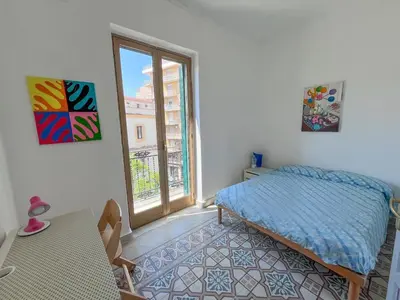 a bedroom with a bed and a window and a table at Corso Tugher in Palermo