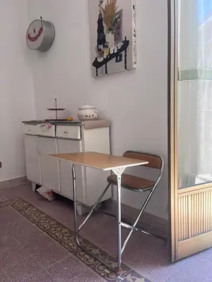 a table and a chair in a kitchen at Corso Tugher in Palermo